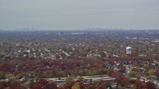 AX117_003 - 5.5K aerial stock footage of a suburban neighborhood and NYC skyline in Autumn, Farmingdale, New York