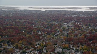 AX117_027E - 5.5K aerial stock footage of residential suburbs in Autumn, Merrick, New York