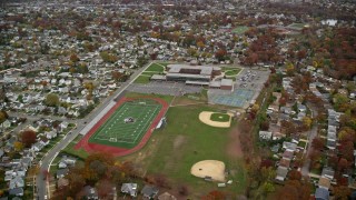AX117_033E - 5.5K stock footage aerial video of a suburban high school in Autumn, Merrick, New York
