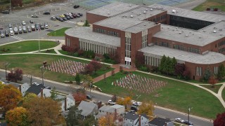 AX117_038E - 5.5K aerial stock footage of a flag display at high school in Autumn, Merrick, New York