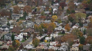 AX117_042E - 5.5K aerial stock footage of passing and flying away from suburban homes in Autumn, Bellmore, New York