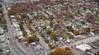 AX117_046E - 5.5K aerial stock footage of shops and suburban homes in Autumn, Wantagh, New York