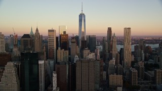 AX118_075 - 5.5K aerial stock footage of the top of Freedom Tower and Lower Manhattan skyscrapers at sunrise in New York City