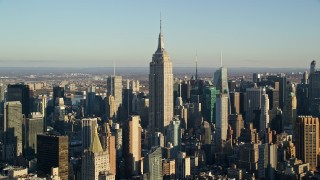 AX118_177E - 5.5K aerial stock footage of approaching the towering Empire State Building at sunrise in New York City