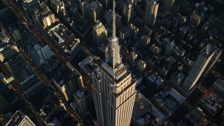 AX118_181E - 5.5K stock footage aerial video approach and tilt to bird's eye of the Empire State Building at sunrise in New York City