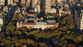 AX118_193 - 5.5K aerial stock footage of orbiting the Museum of Natural History and trees with Autumn leaves at sunrise in New York City