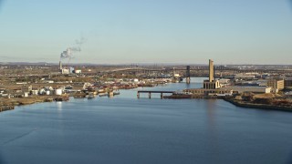 AX118_226 - 5.5K aerial stock footage of riverfront factories and bridges at sunrise in Kearny and Newark, New Jersey