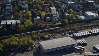 AX119_067E - 5.5K aerial stock footage of tracking commuter train in Autumn, Yonkers, New York