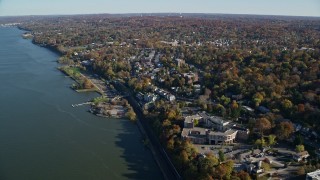 AX119_078E - 5.5K aerial stock footage video of passing the waterfront town of Dobbs Ferry, New York, in Autumn