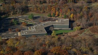 AX119_100E - 5.5K aerial stock footage of an isolated office building in Autumn, Sleepy Hollow, New York