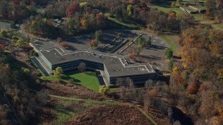AX119_102E - 5.5K aerial stock footage of an orbit of an isolated office building in Autumn, Sleepy Hollow, New York