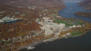 AX119_180E - 5.5K aerial stock footage of a wide orbit around West Point Military Academy in Autumn, West Point, New York