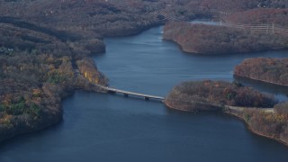 AX119_207 - 5.5K aerial stock footage of small bridge over New Croton Reservoir in Autumn, New York