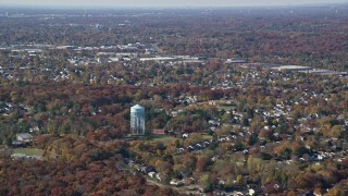 AX119_247 - 5.5K aerial stock footage of a water tower and suburban neighborhoods in Autumn, Syosset, New York