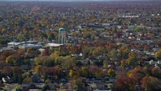 AX119_254 - 5.5K aerial stock footage of a suburban residential neighborhood and water tower in Autumn, Farmingdale, New York