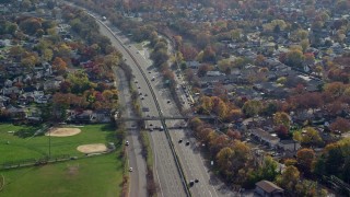 AX120_010 - 5.5K aerial stock footage orbit light traffic on a freeway in Autumn, Seaford, New York