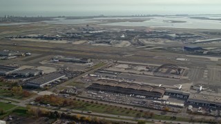 AX120_050E - 5.5K aerial stock footage of flying toward John F. Kennedy International Airport in Autumn, in New York