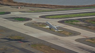 AX120_054E - 5.5K aerial stock footage of an airliner cruising down runway at JFK Airport, New York