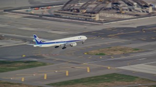 AX120_068E - 5.5K aerial stock footage of a commercial jet approaching and landing at JFK Airport in Autumn