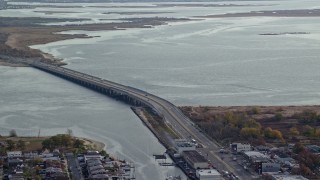AX120_072E - 5.5K aerial stock footage of a small bridge spanning a bay in Autumn, Jamaica, New York