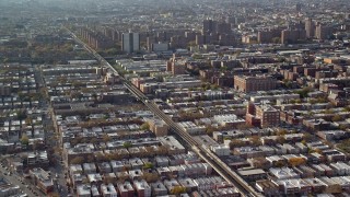 AX120_077E - 5.5K aerial stock footage of row houses, elevated rail, and public housing in Autumn, Brooklyn, New York City