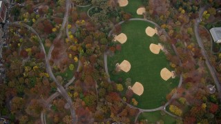 AX120_197 - 5.5K stock footage aerial video of bird's eye of a theater and baseball diamonds in Central Park in Autumn, New York City