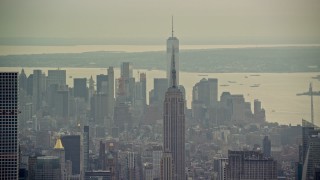 AX120_225E - 5.5K aerial stock footage of the top of the Empire State Building and Lower Manhattan, New York City