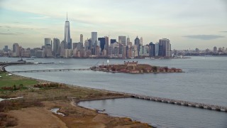 AX120_261 - 5.5K aerial stock footage of Lower Manhattan and Ellis Island seen from Liberty Park in Autumn, New York City