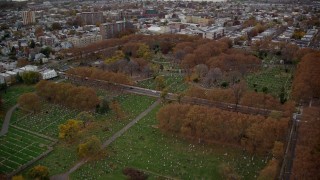 AX120_265E - 5.5K aerial stock footage approach a Jersey City cemetery by a freeway in Autumn, New Jersey
