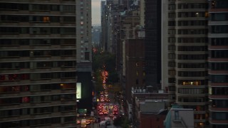 AX121_068E - 5.5K aerial stock footage of Midtown city canyons and reveal UN Building at twilight in New York City