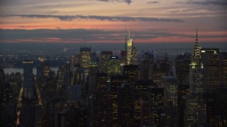 AX121_115E - 5.5K aerial stock footage orbit Midtown high-rises and reveal Chrysler Building at twilight, New York City