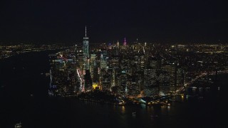 AX121_193E - 5.5K aerial stock footage orbit the tip of Lower Manhattan at Night in New York City