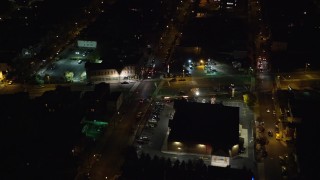 AX122_004 - 5.5K aerial stock footage approach shops by a city street in Jersey City, New Jersey, at Night