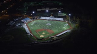 AX122_007E - 5.5K stock footage aerial video of approaching and orbiting a football and baseball stadium at Night in Jersey City, New Jersey