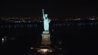 AX122_013E - 5.5K aerial stock footage orbit the front of the Statue of Liberty at Night in New York