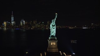AX122_020E - 5.5K aerial stock footage of an orbit around the side of the Statue of Liberty at Night in New York
