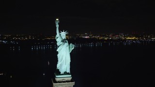AX122_023 - 5.5K aerial stock footage of the front of the Statue of Liberty at Night in New York