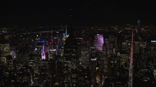 AX122_082E - 5.5K aerial stock footage orbit Empire State Building with the roof in darkness at Nighttime in Midtown, NYC