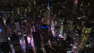 AX122_125E - 5.5K aerial stock footage orbit skyscrapers around Times Square at Night in Midtown Manhattan, New York City
