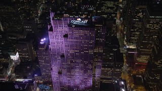 AX122_136E - 5.5K stock footage aerial video approach Rockefeller Center at Night in Midtown, New York City