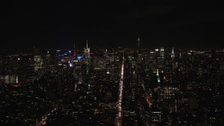 AX122_147E - 5.5K aerial stock footage of dark Empire State Building and Midtown skyscrapers at Night, New York City
