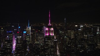 AX122_151E - 5.5K aerial stock footage approach the Empire State Building at Night in Midtown Manhattan, New York City