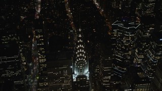 AX122_160E - 5.5K aerial stock footage of orbiting the top of the Chrysler Building at Nighttime in Midtown, New York City