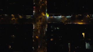AX122_235E - 5.5K aerial stock footage of a bird's eye of cars traveling on 2nd Avenue at Night in East Village, New York City