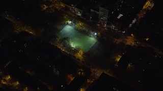 AX122_239 - 5.5K aerial stock footage orbit a soccer field on the Lower East Side at Night in New York City