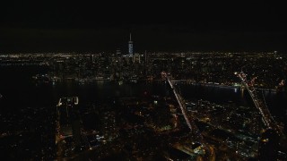 AX122_275E - 5.5K aerial stock footage fly over Brooklyn to approach bridges over East River and Lower Manhattan at Night, NYC