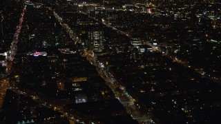 AX123_024E - 5.5K stock footage aerial video orbit city streets and office buildings in Harlem at Night in New York City