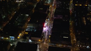 AX123_038 - 5.5K aerial stock footage fly away from a Harlem shop on 125th Street at Night in NYC