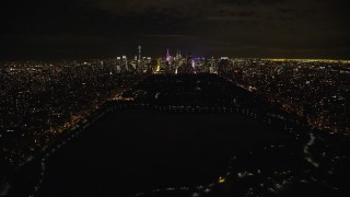 AX123_052E - 5.5K stock footage aerial video fly over Central Park and approach Midtown Manhattan at Night in New York City