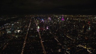 AX123_074E - 5.5K aerial stock footage of approaching skyscrapers of Midtown at Nighttime in NYC